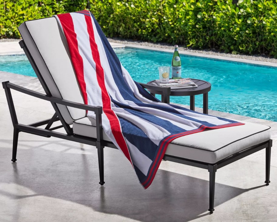 Beach towel draped across a chair next to a pool