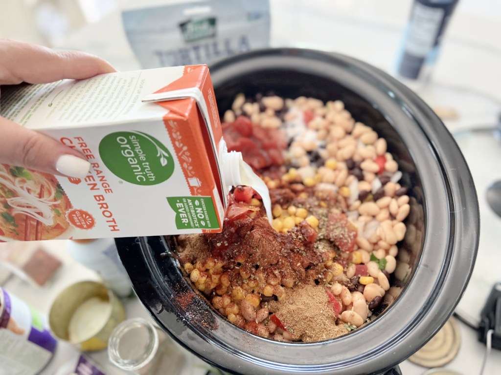 adding chicken broth to tortilla soup