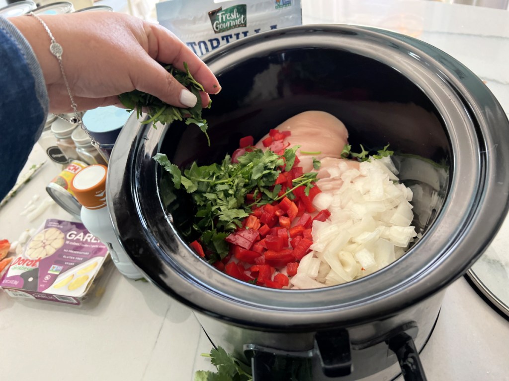 adding cilantro to chicken tortilla soup