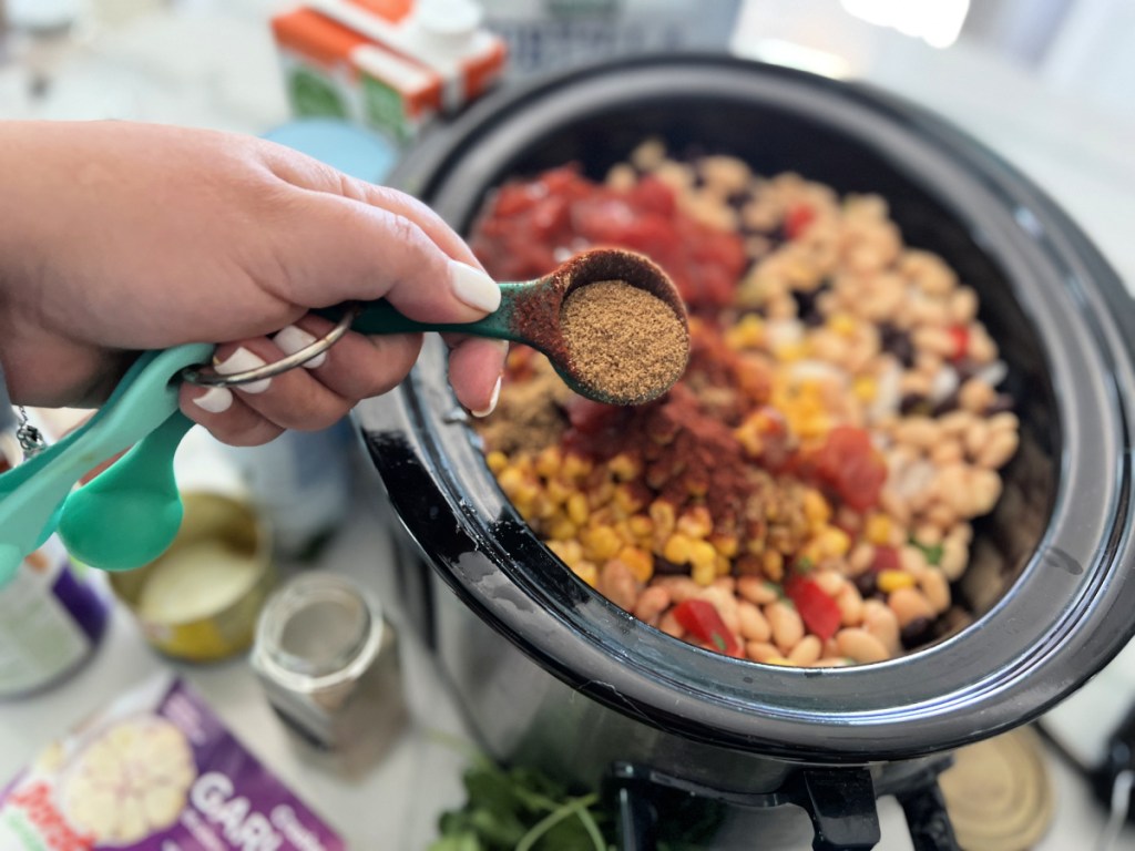 adding spices to chicken tortilla soup