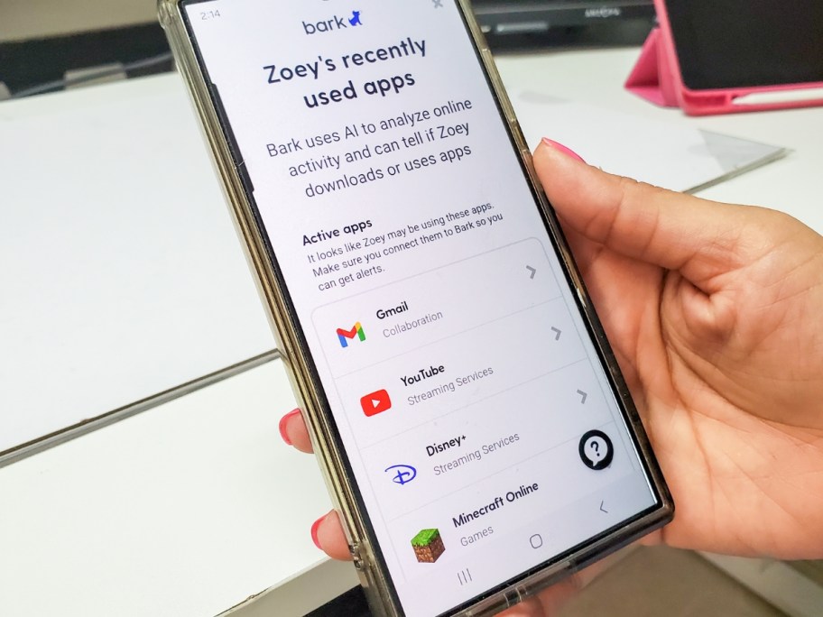 person's hand holding a smart phone with the Bark app open showing their child's app usage
