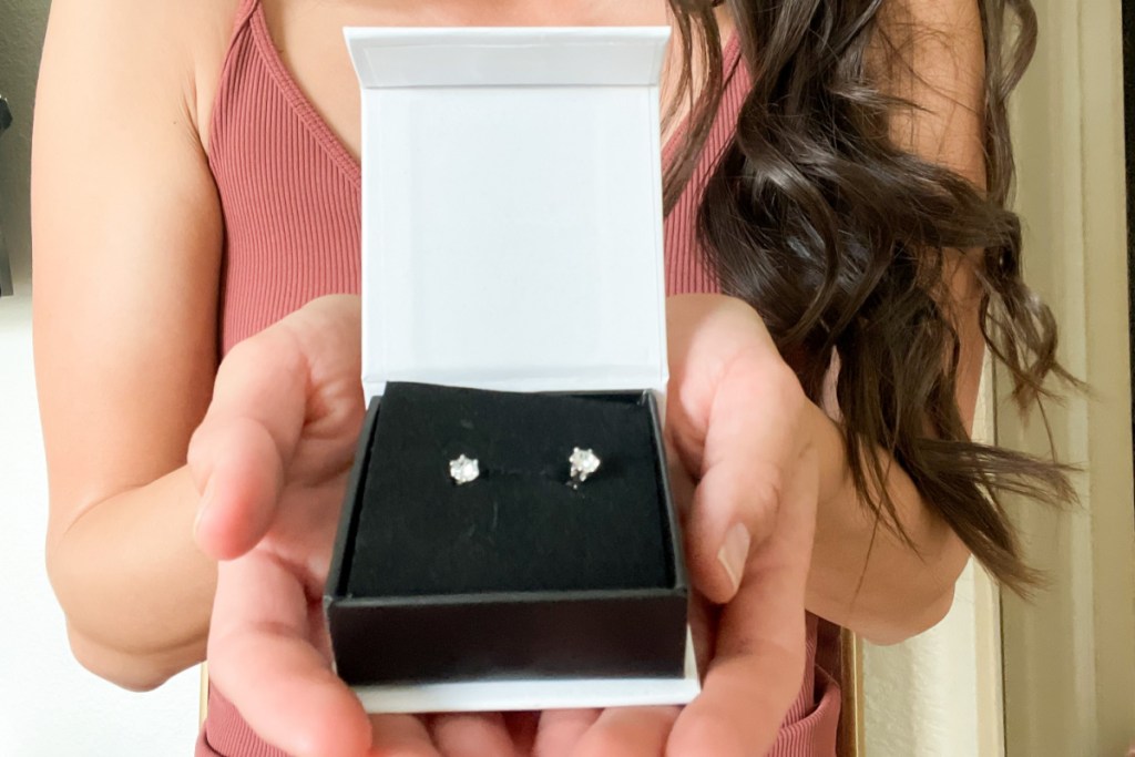 hands holding out earring box