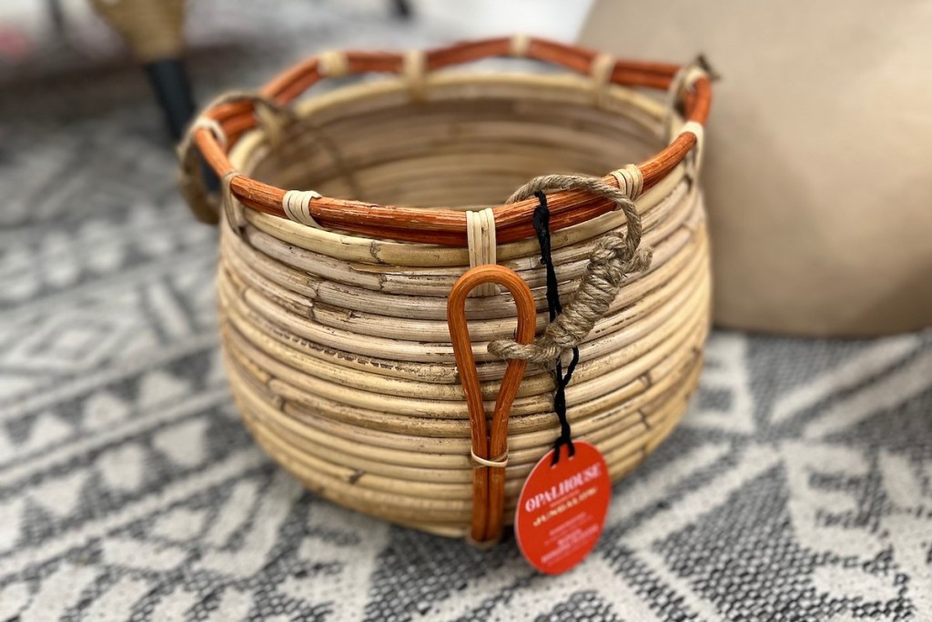 woven natural colored basket sitting on gray and white patterned rug