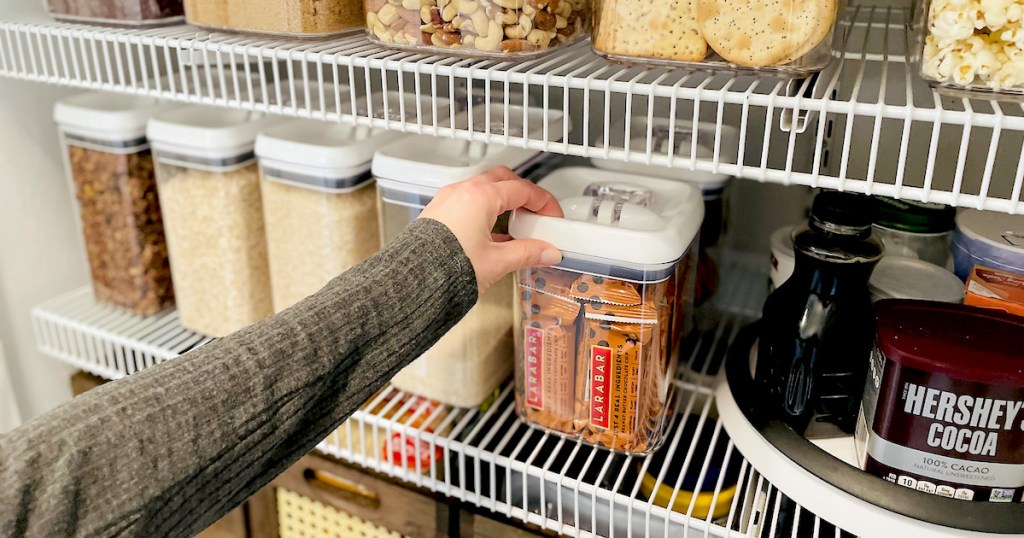 woman with hand on top of walmart pantry organization ideas on shelf