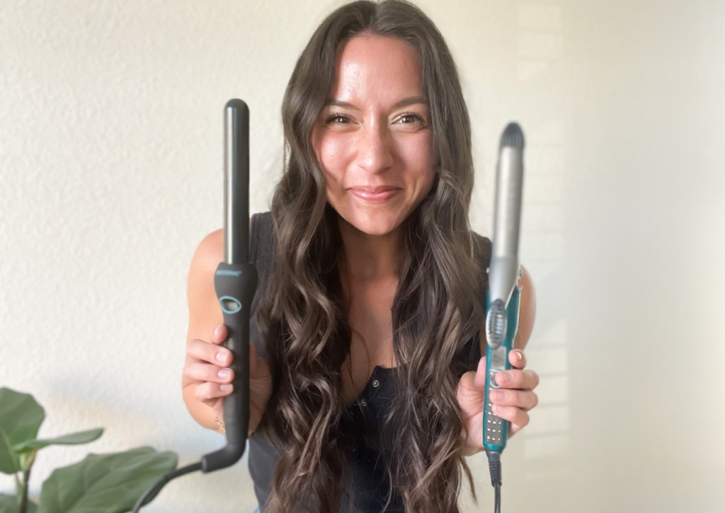 woman with curly hair holding curling irons