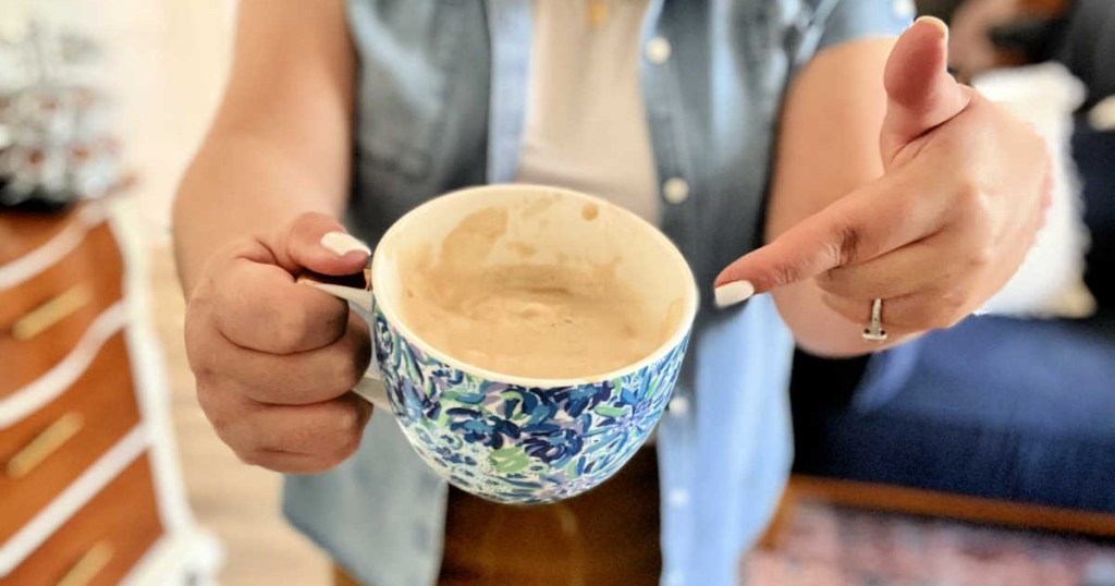 woman pointing to a homemade caffe latte