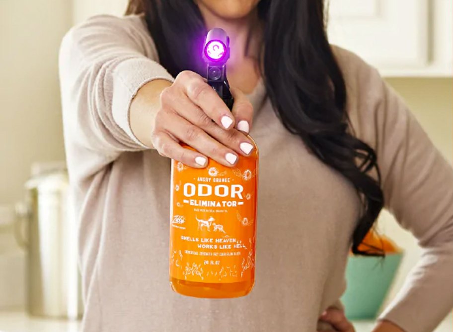 woman pointing bottle of angry orange with UV flashlight on top