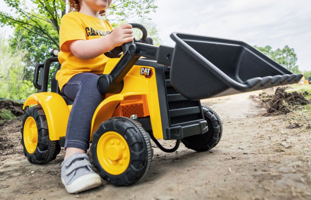 kid on yellow frontloader ride on toy