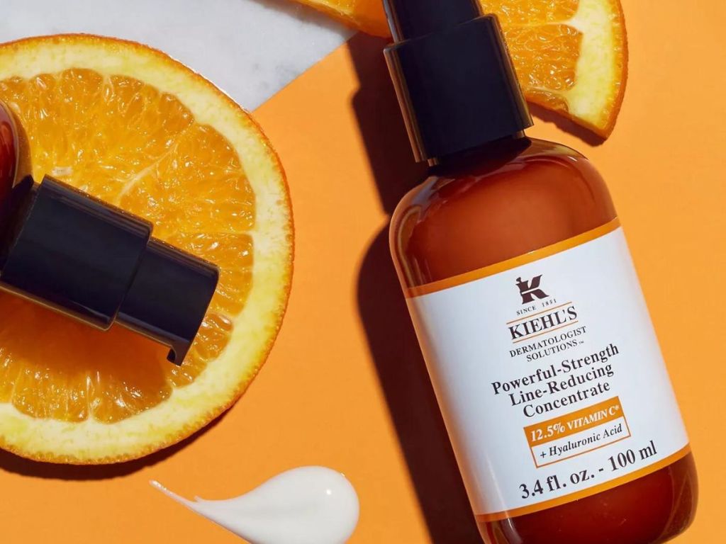 bottles of Kiehl's Powerful-Strength Vitamin C Serum laying on orange slices 