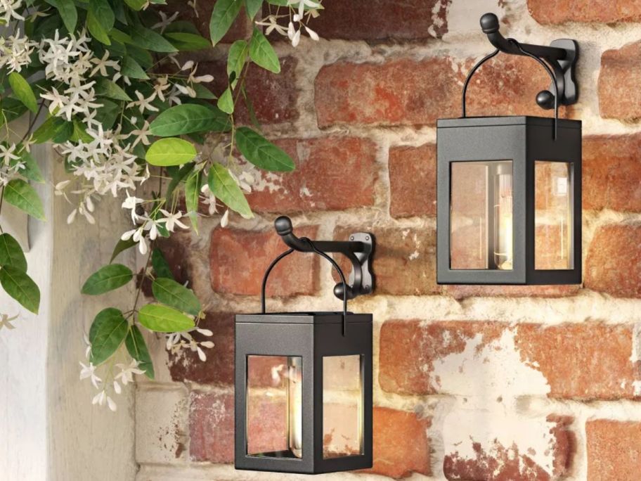 A brick wall with two Threshold Solar LED Clip Window Lanterns hanging on it
