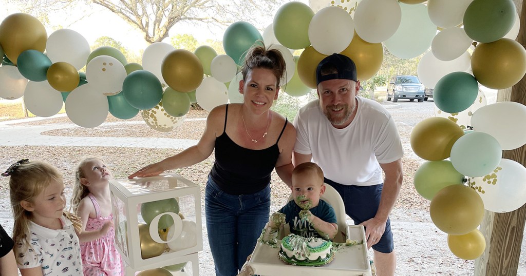 family underneath diy balloon arch