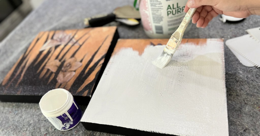 painting canvas with white paint