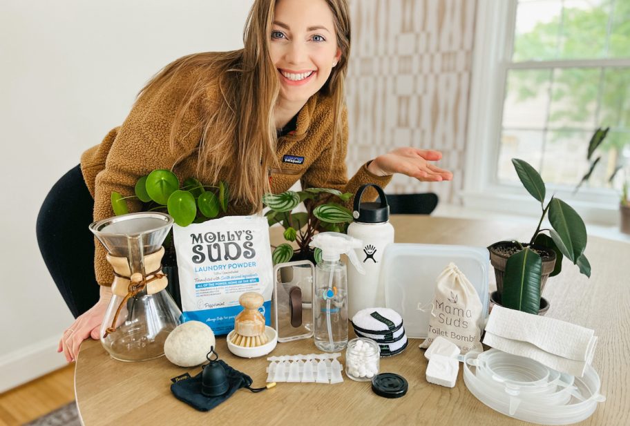 woman hovering over table full of reusable and eco friendly products