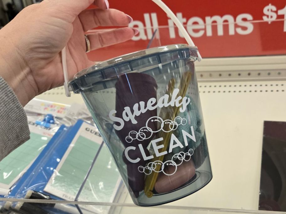 A person holding a Bullseye Playground Everyday Tasks Cleaning Set bucket