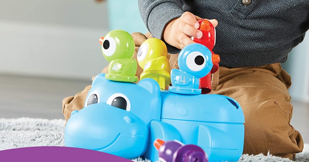 child playing with a hippo learning toy