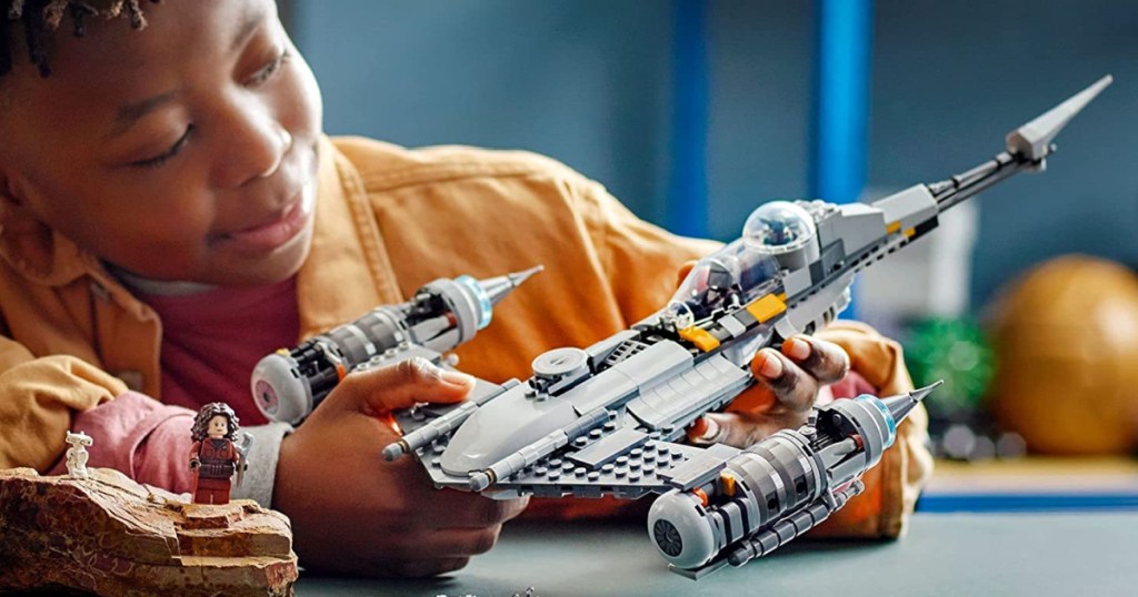 boy playing with Mandalorian Starfighter