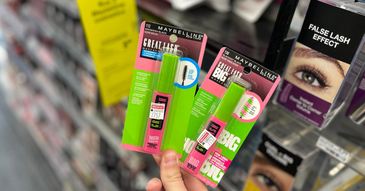 hand holding two mascaras in front of a store shelf