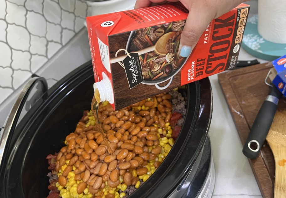 Pouring beef stock into Crockpot Cowboy supper