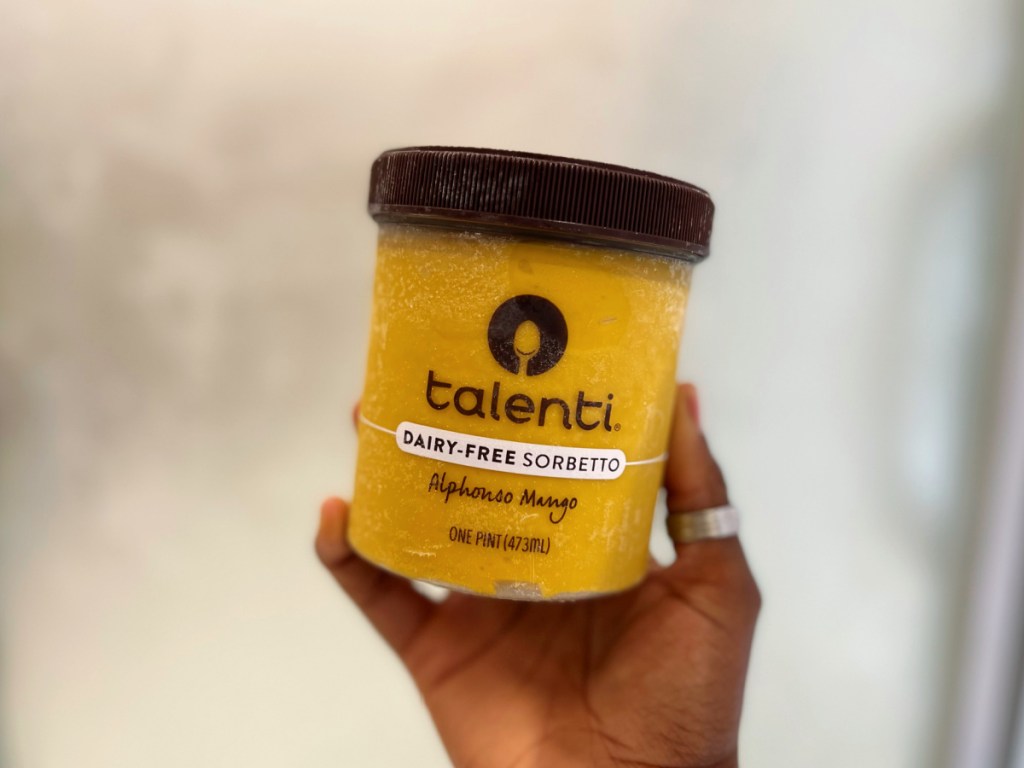 hand holding pint of mango sorbet