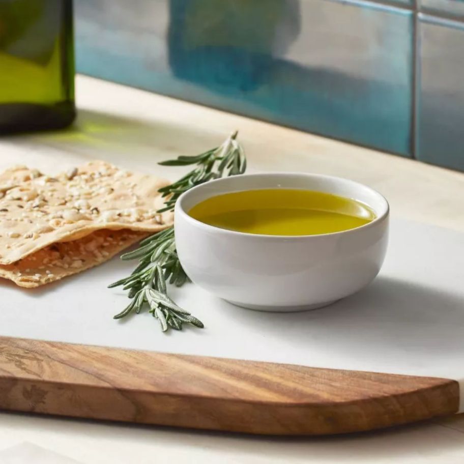 a white dip bowl filled with extra virgin olive oil.