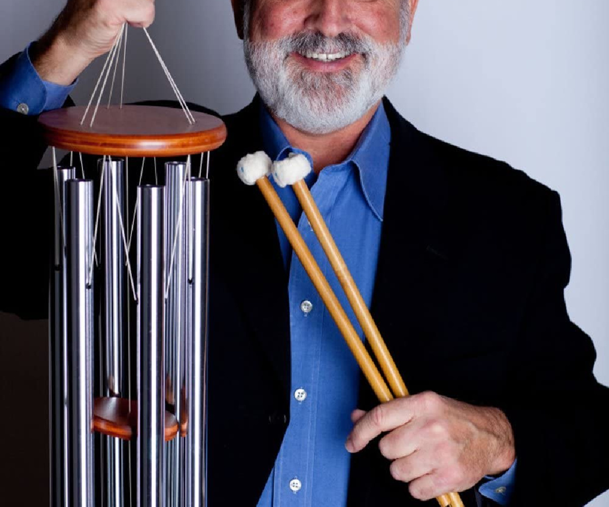 man holding wind chime and sticks