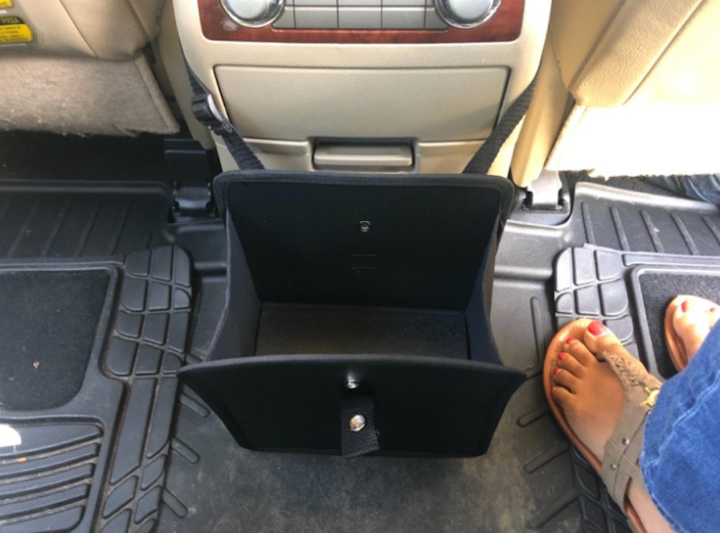 empty black basket strapped to center console in car