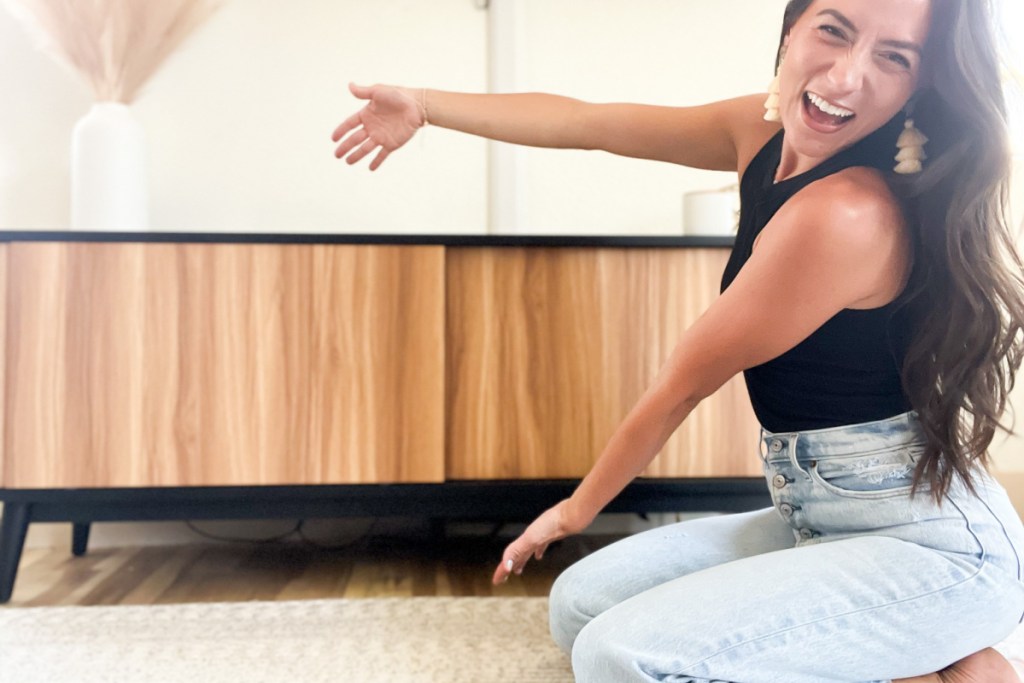 woman showing wood tv console