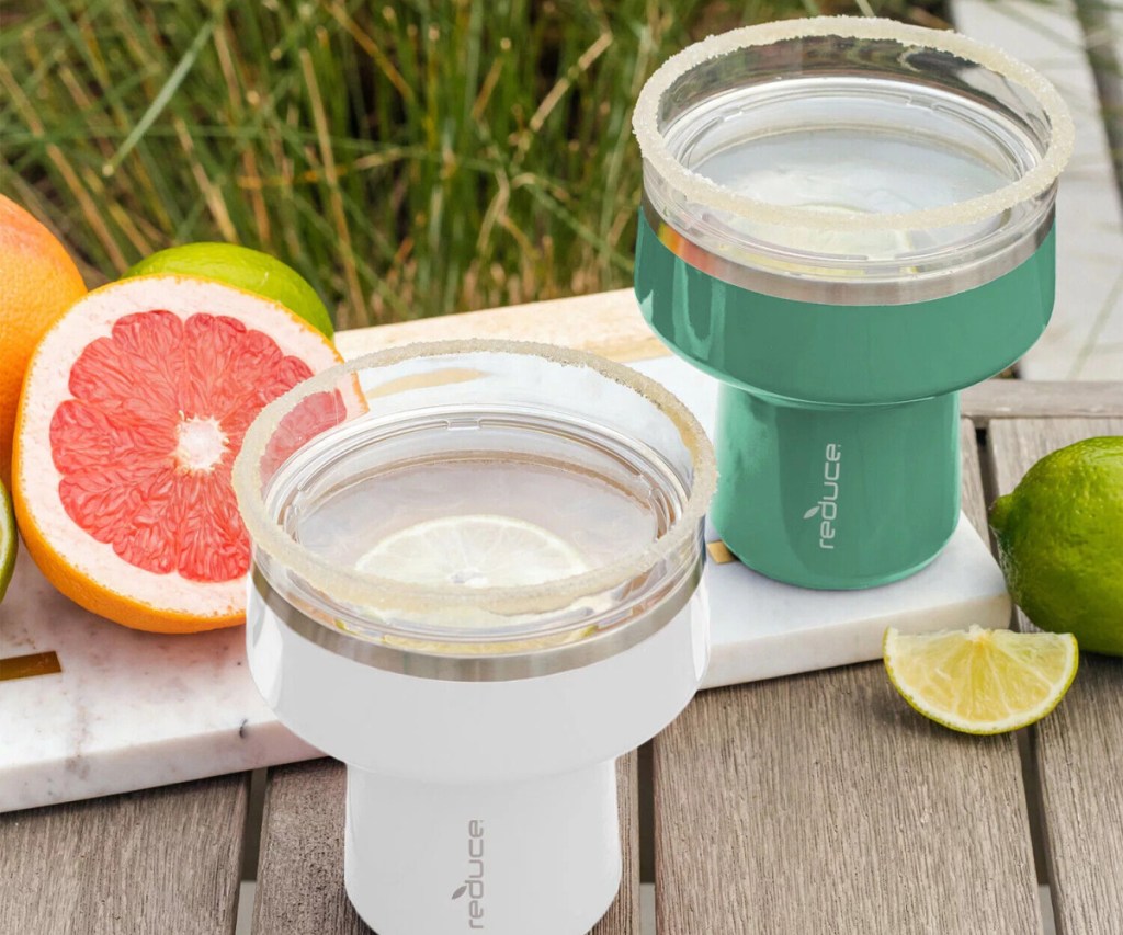 green and white reduce saltini tumblers next to cut citrus fruit