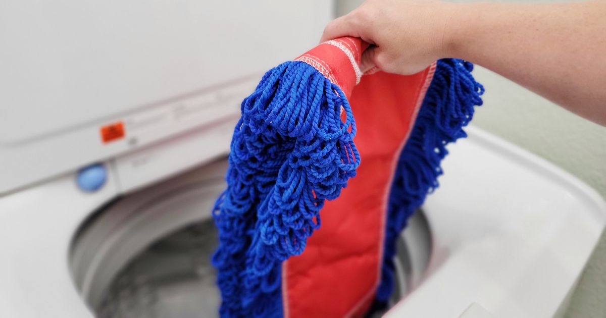 hand placing microfiber mop head into washing machine