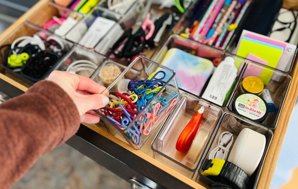 hand holding clear drawer organizer with bag clips inside