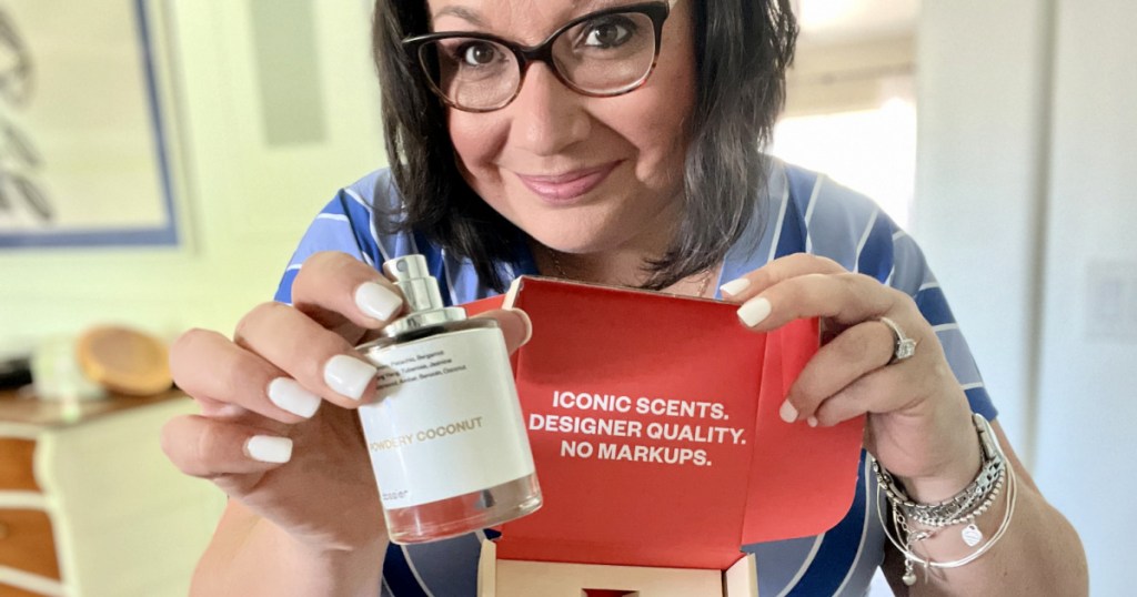 woman holding a dossier perfume from walmart