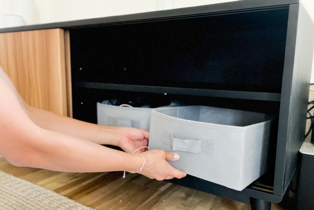 hands putting storage box on shelf