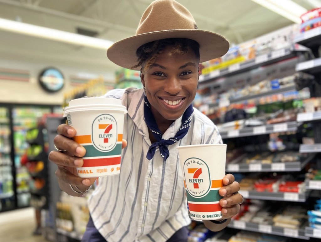 woman holding 2 cups of 7-11 coffee