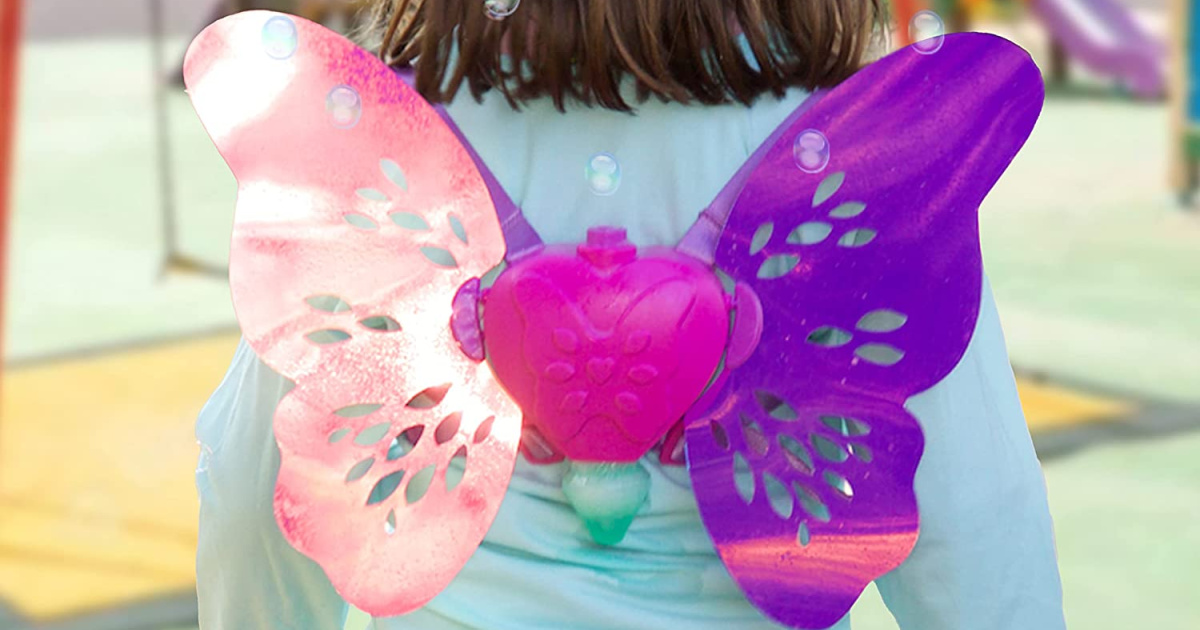 girl wearing fairy wing toy that releases bubbles