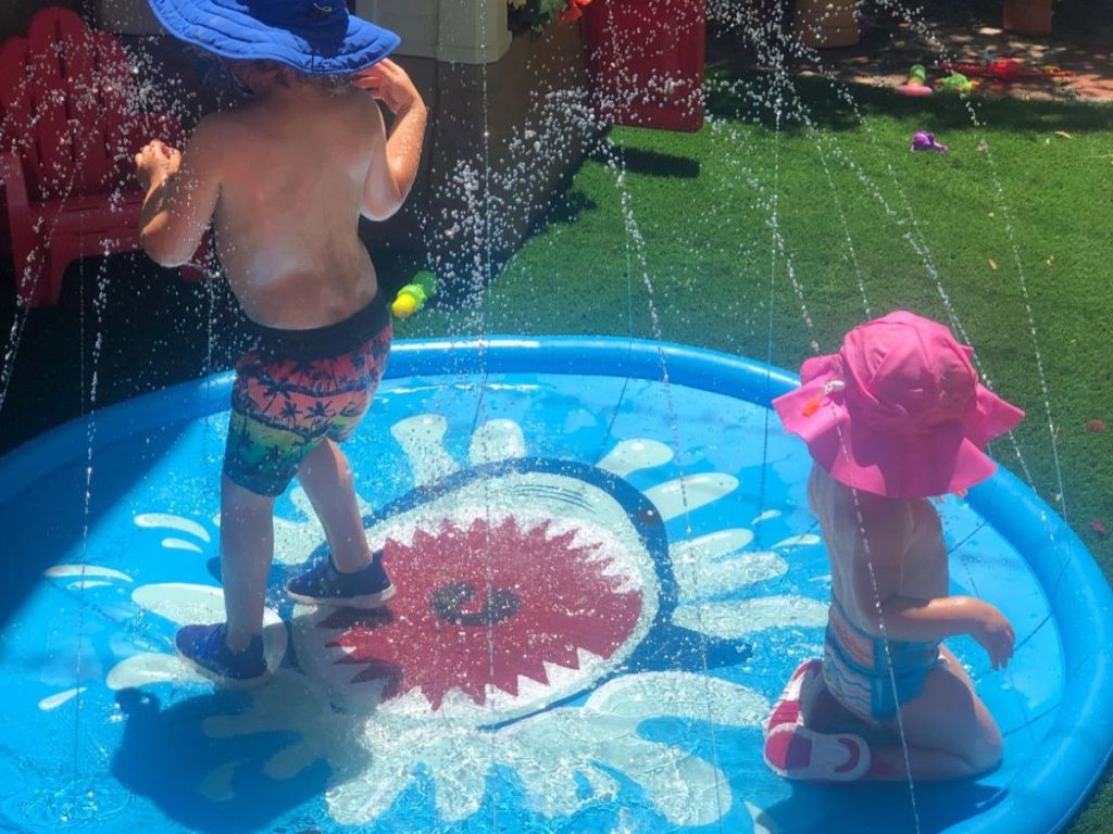 Two small children playing on a Jasonwell shark splash pad