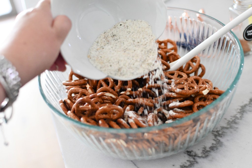 adding seasonings to pretzels