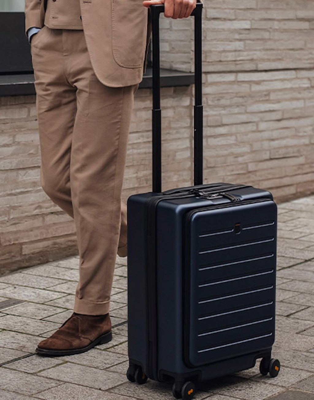 business man walking on sidewalk with black luggage