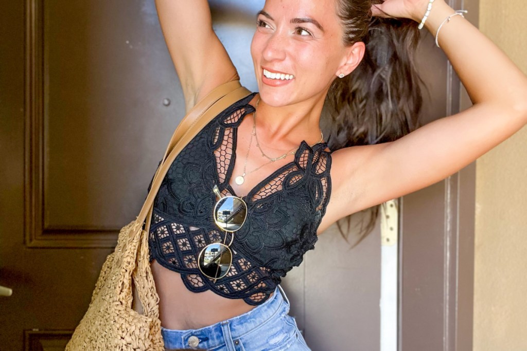 woman outside wearing black floral bralette