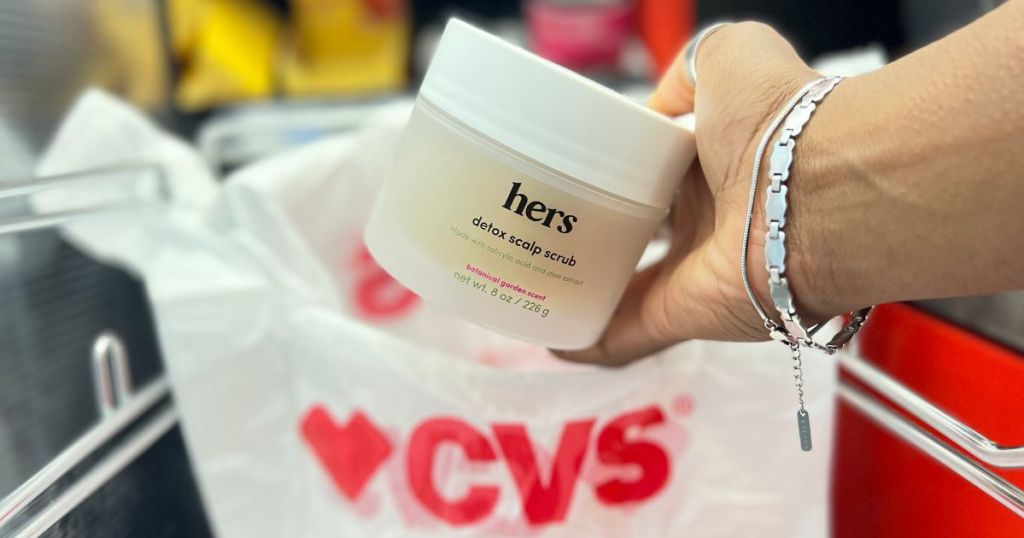 hand putting hers detox scalp scrub into CVS bag