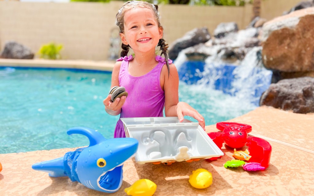 girl next to pool toys