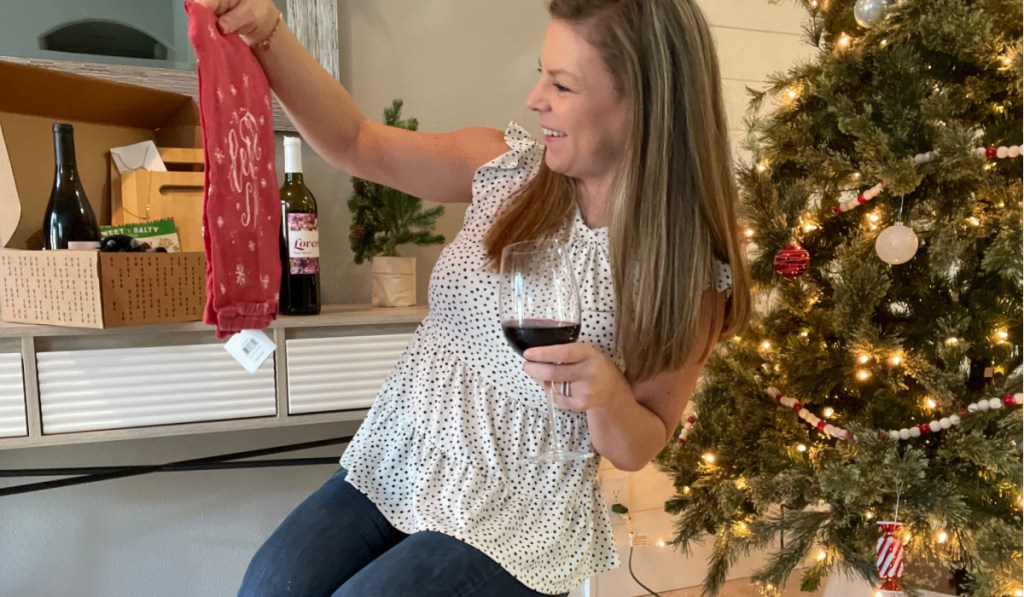 woman holding wine and tea towel