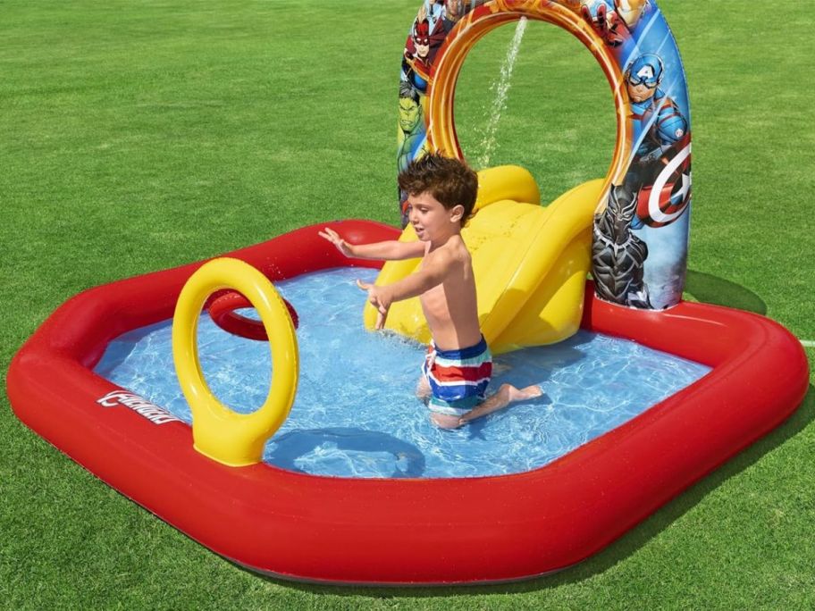 Boy playing in a Bestway Marvel's Avengers Assemble Kids Inflatable Water Play Center