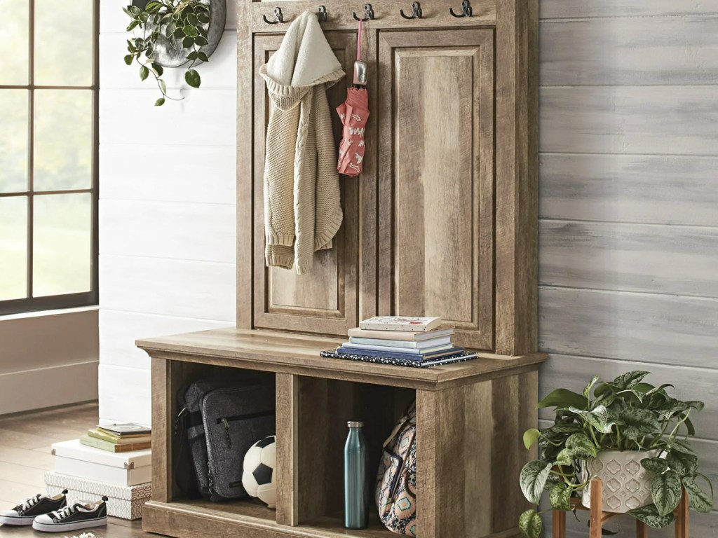 Storage hall tree with coats hanging on hooks