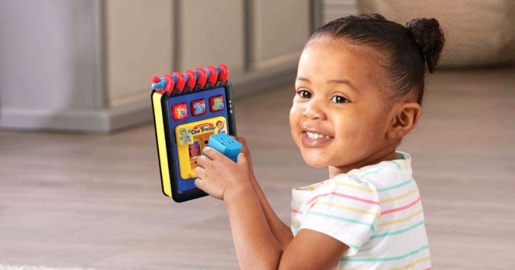 girl holding a LeapFrog Handy Dandy Clue Tracker