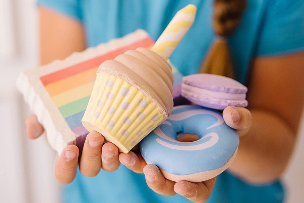 girl holding chalk shaped like cake bakery items