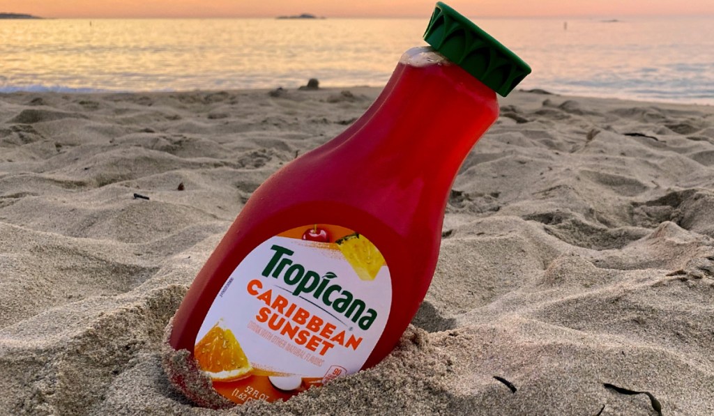 bottle of juice in sand at beach