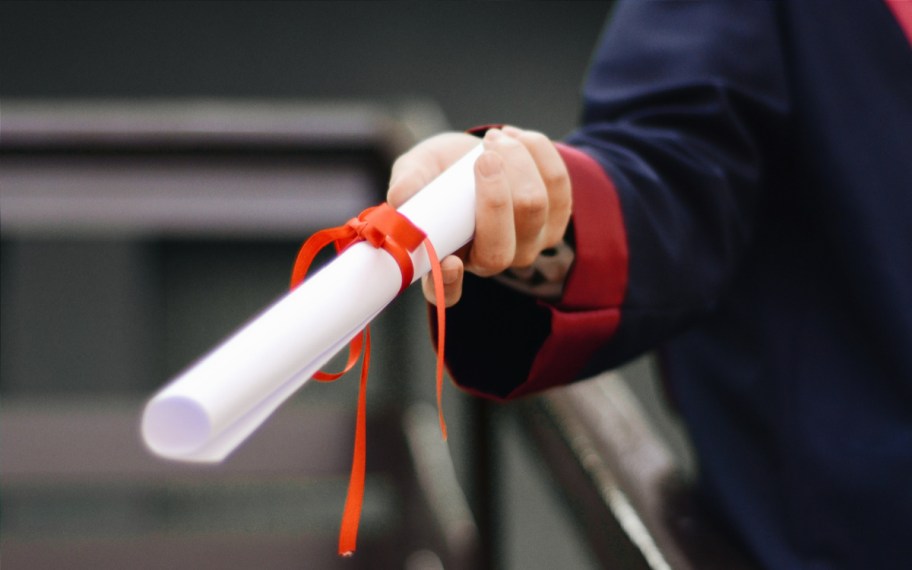 hand holding a college diploma