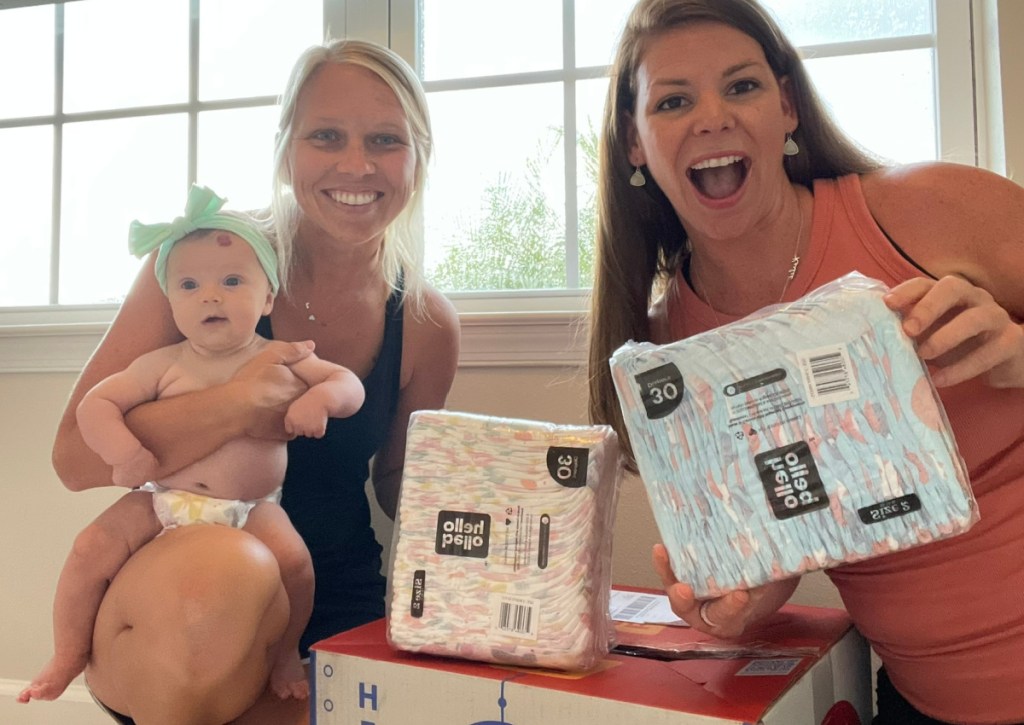 woman holding baby with diapers