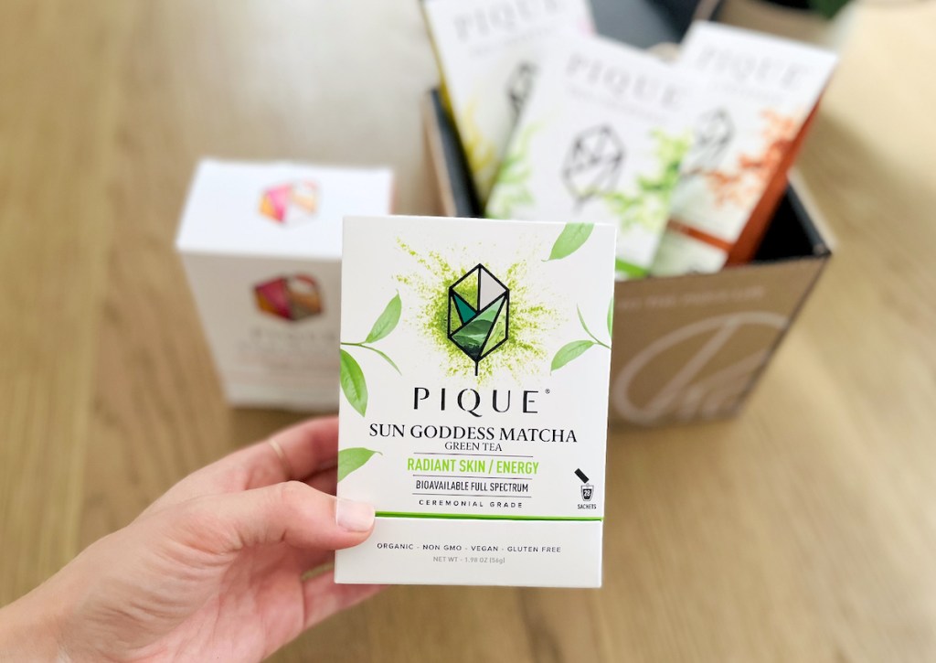 hand holding a box of pique matcha 