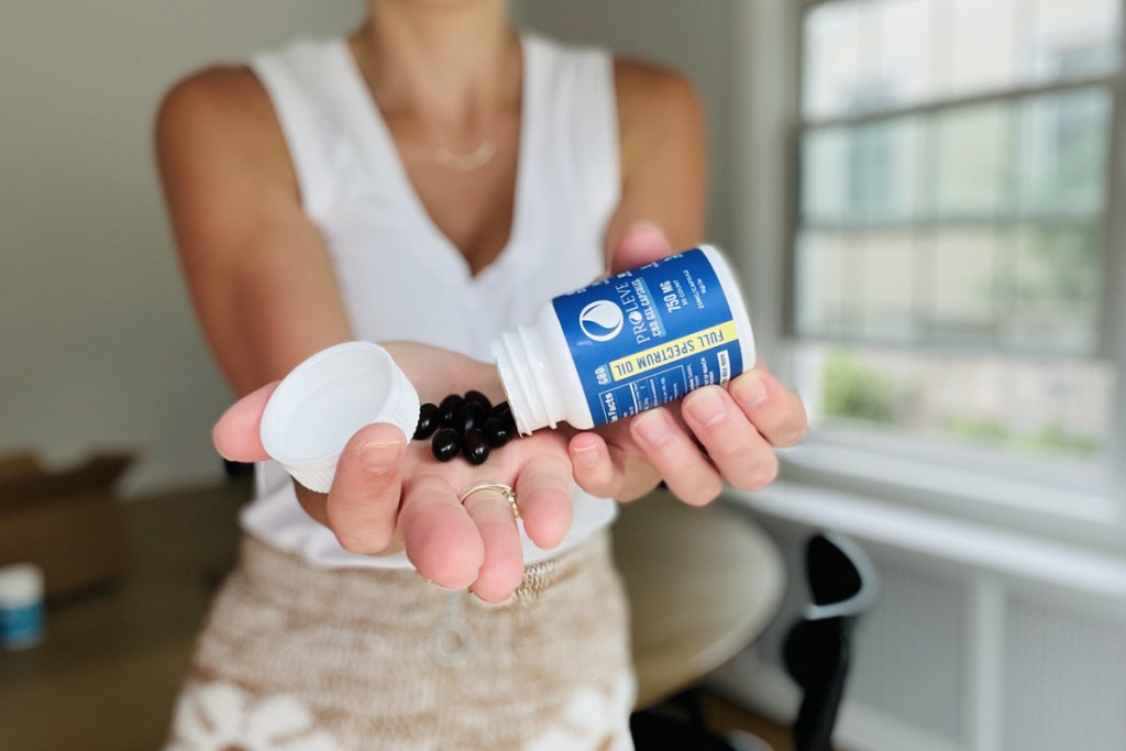 woman pouring proleve sleep supplement pills from a bottle into her hand